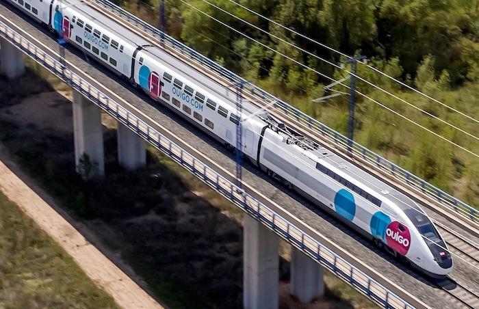 un train ouigo en train de rouler sur un pont 