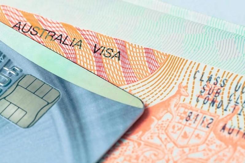 Le visa australien posé sur une table avec une carte de crédit dessus 