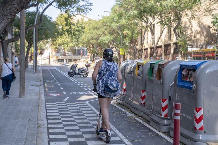 Une femme roule en trotinette à barcelone: 