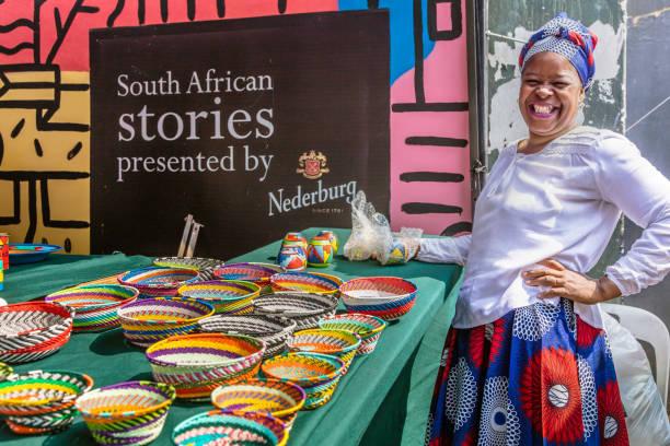 Une femme devant son stands d'objets colorés à vendre