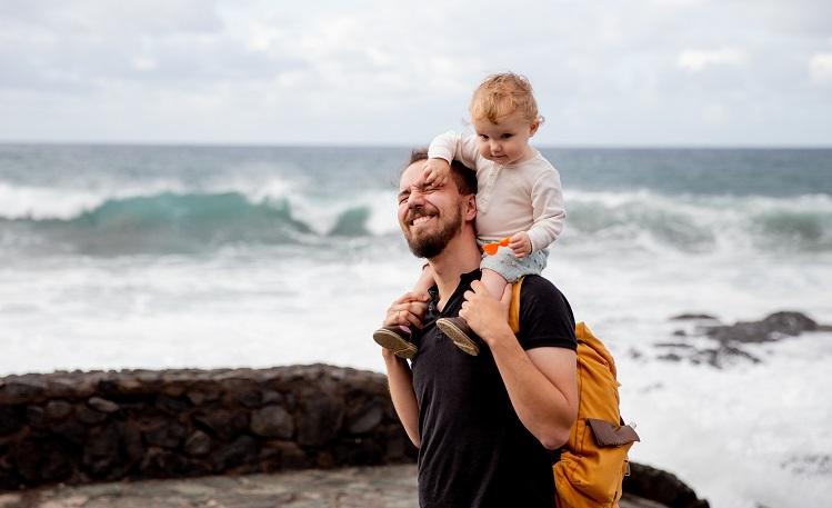 un père porte son enfant sur les épaules