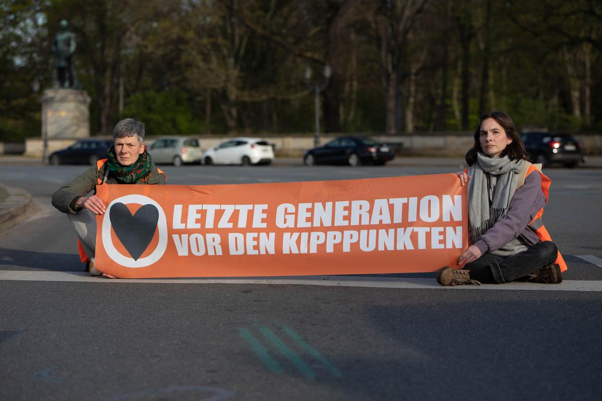 des militants de letzte generation avec une pancarte, dans les rues de berlin