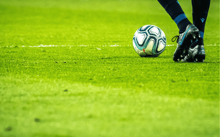 joueur français avec un ballons sur un terrain de foot 