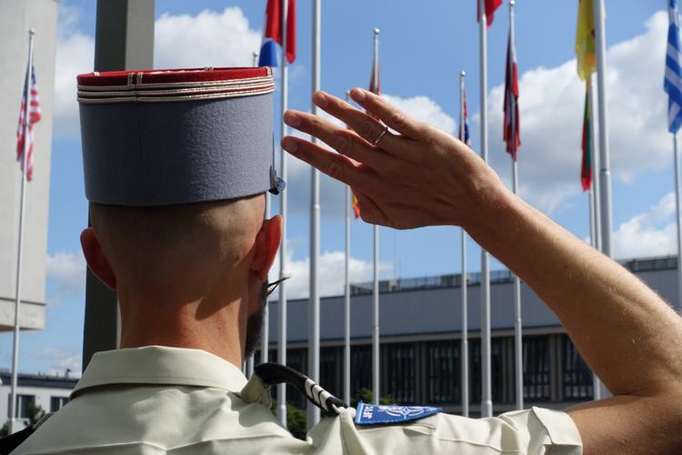 Salut militaire devant les drapeaux de l'OTAN - Photographe : Bénédicte Mezeix