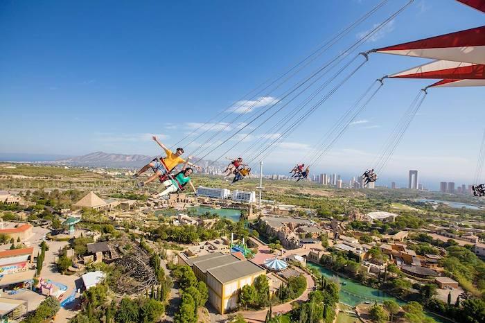 des personnes sur un manège au dessus d'un paysage naturel dans le parc Terra Mitica sur la Costa Blanca