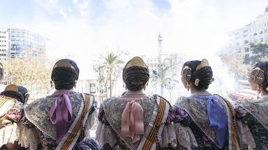 des falleras de dos en train d'assister à une mascletà depuis l'hotel de ville pendant les Fallas