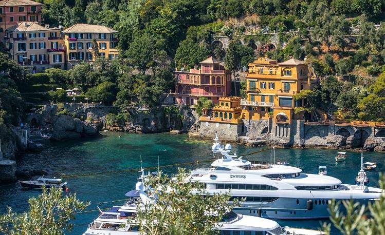 yatch blanc dans la baie devant les maisons colorées de portofino