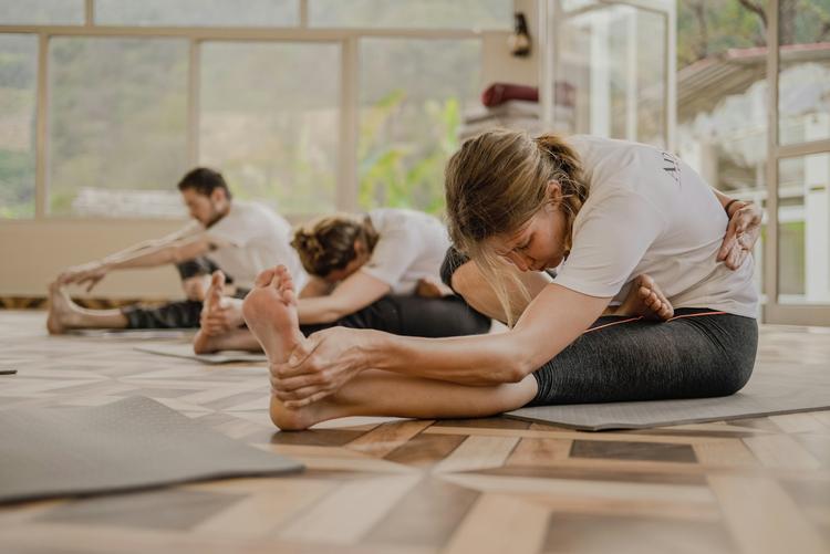 un groupe de personnes faisant du yoga dans une salle