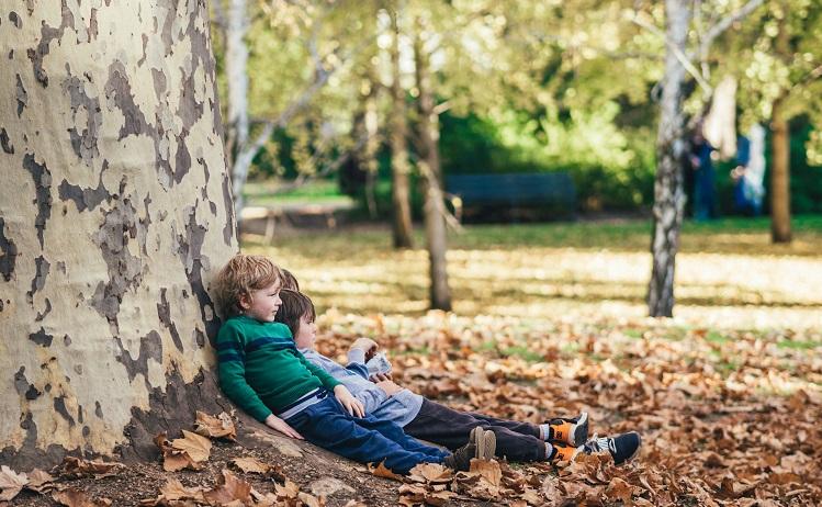 enfants allongés au pied d'un arbre