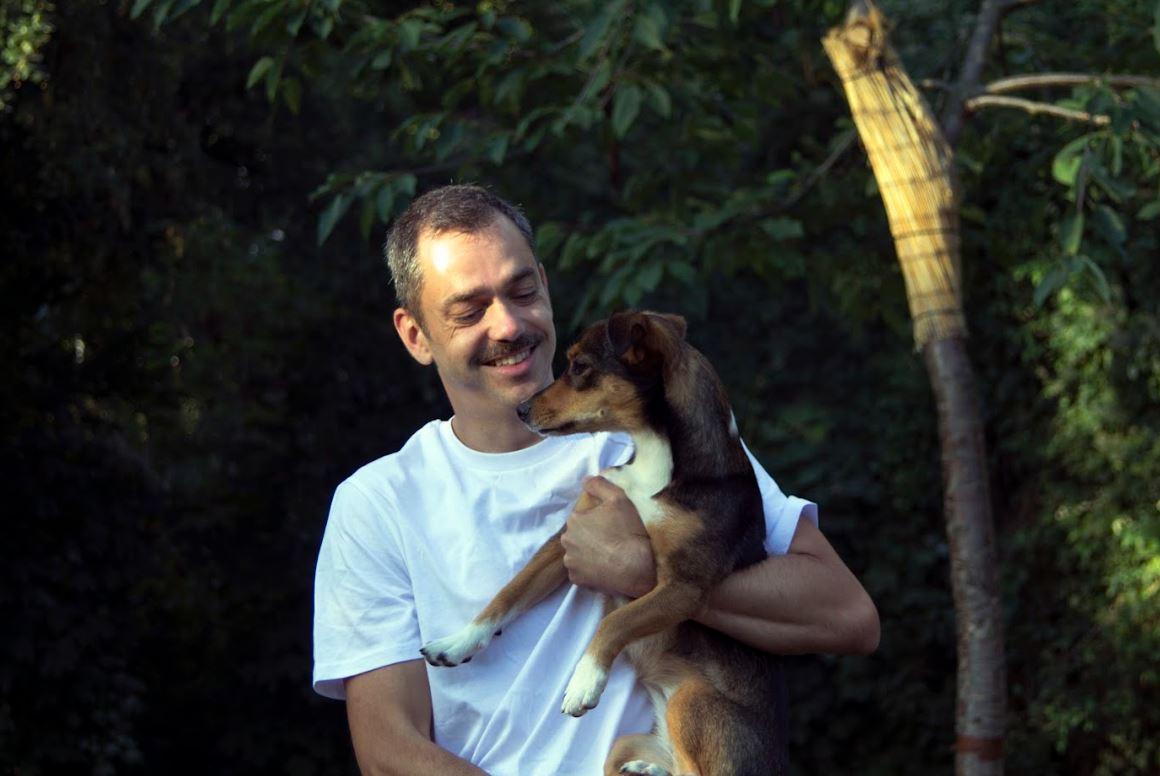 Un homme avec un chien dans les bras.