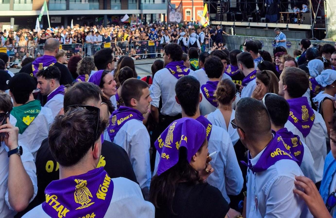 Foule festive lors des fêtes basques : jeunes vêtus de blanc et de foulards violets, symbole de leur cuadrilla, participent aux traditions locales