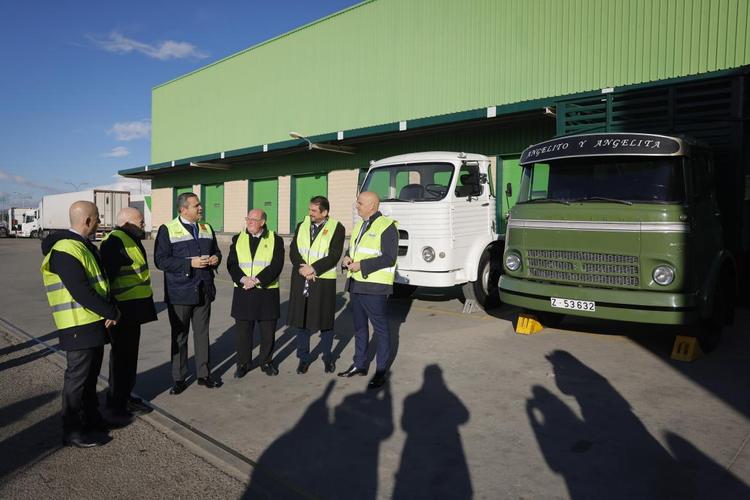 des responsables en gilets de sécurité devant des camions 