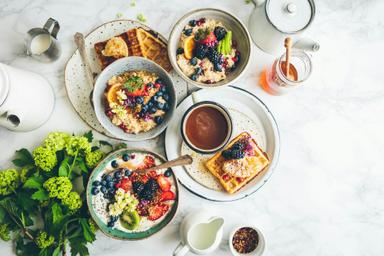 Un brunch gourmand avec des bowls de fruits frais, des gaufres croustillantes au miel et une tasse de café fumant