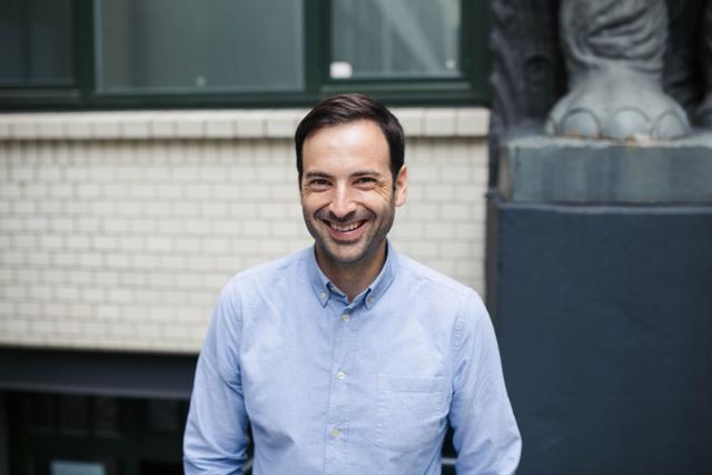 Portrait de face et buste d'Antoine Verger, homme blanc avec les cheveux bruns et courts, qui sourit en regardant l'objectif