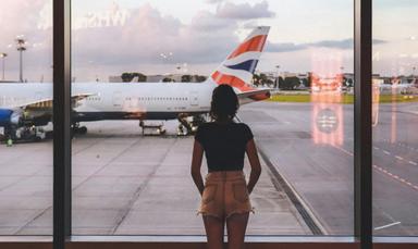 Femme qui regarde le tarmac, attendant pour son avion