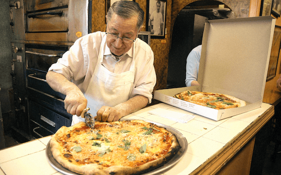 Chez Di Fara à Brooklyn, le Chef Dominic De Marco offre des pizzas faites à la main pour honorer les clients qui attendent leur tour. Crédit : Zagat Buzz. CC BY-NC-SA 2.0.