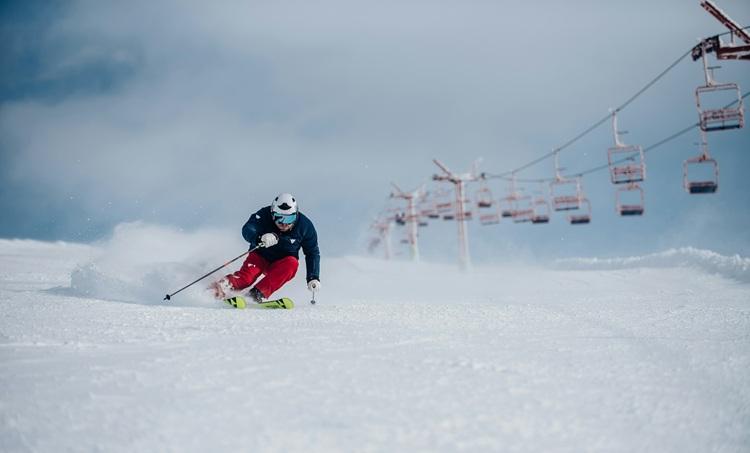 une personne descend à ski une montagne enneigée