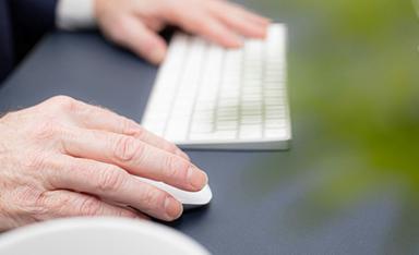 personne tenant un clavier d'ordianteur blanc