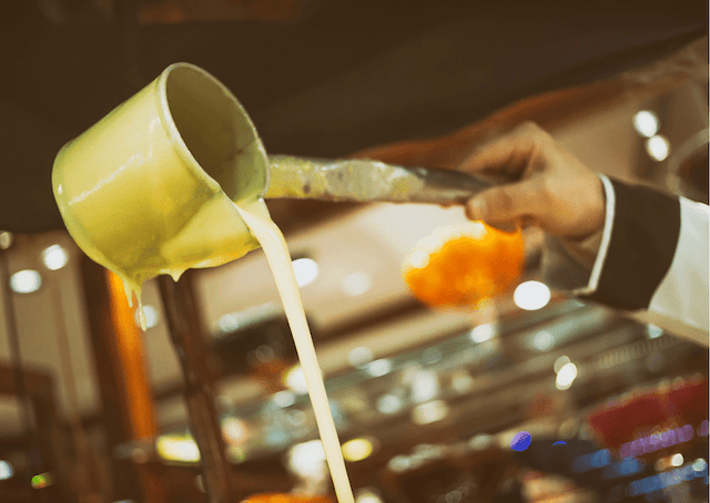 Geste du vendeur versant la boza, boisson traditionnelle turque servie à Istanbul