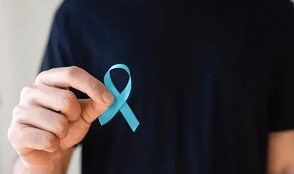 image movember homme qui tient noeud bleu t-shirt noir 