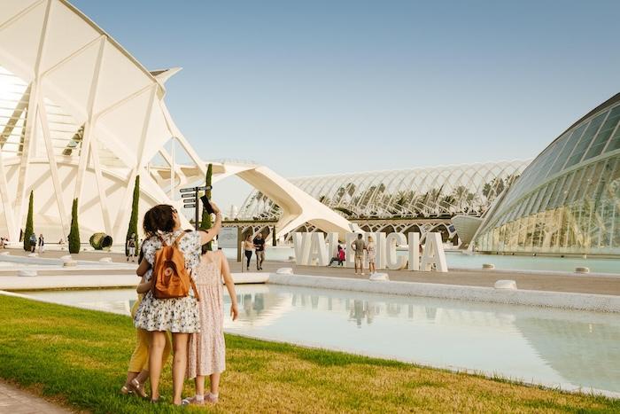 des personnes en train de se prendre en photo devant la cité des arts et des sciences à valencia