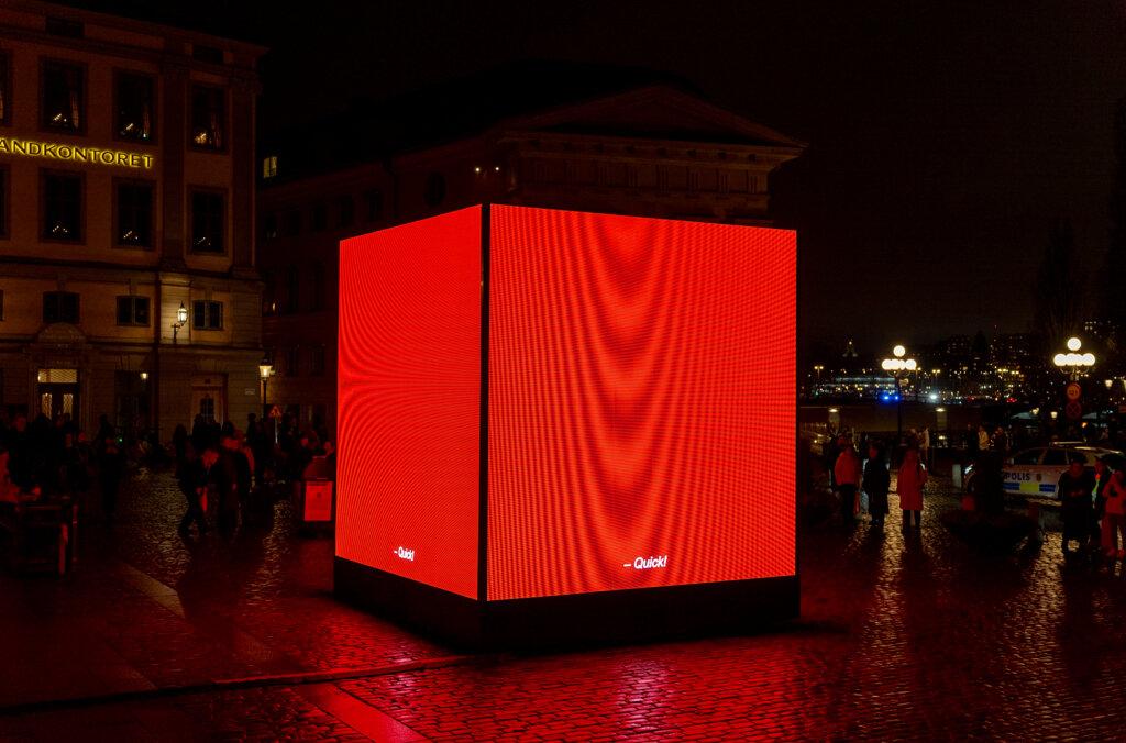 Cube rouge lumineux posé au sol dans Stockholm pour la Nobel Week Lights 