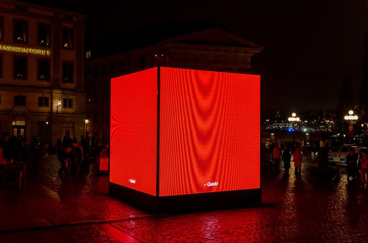 Cube rouge lumineux posé au sol dans Stockholm pour la Nobel Week Lights 