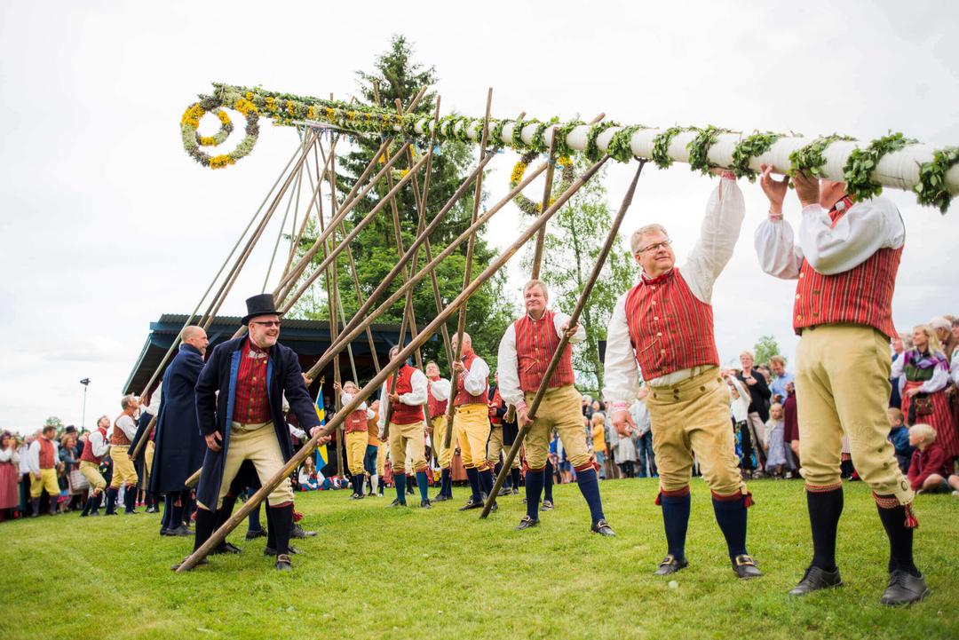 Hommes célébrant Midsommar en tenues traditionnelles
