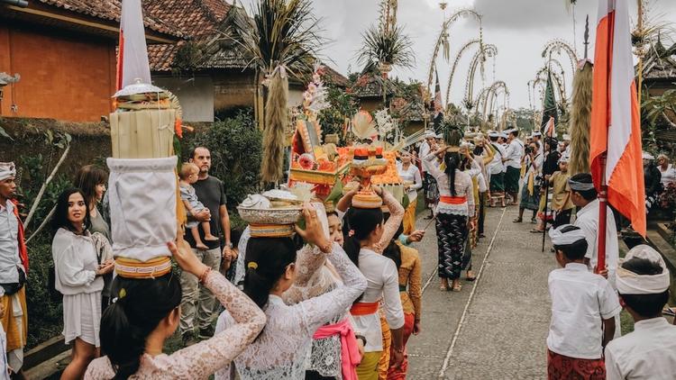 des femmes qui portent des paniers d'offrandes durant une cérémonie à bali en indonésie