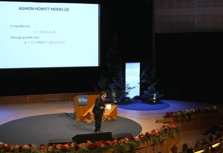 Philippe Aghion, prix nobel 2025 debout sur scène pendant une conférence