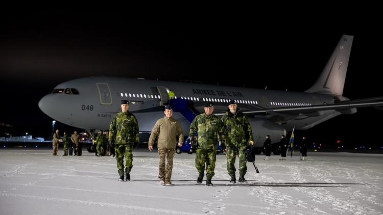 militaires devant un avion pour la Défense