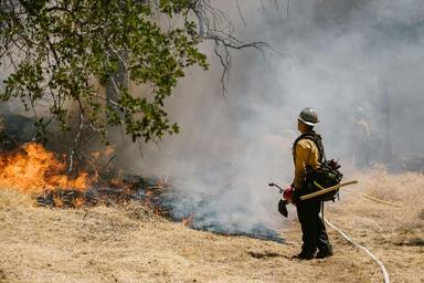 un pompier en train d'éteindre un incendie en espagne