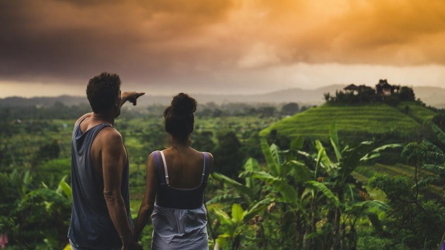 touristes à bali qui admirent la vue dans une rizière au coucher du soleil
