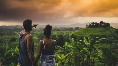 touristes à bali qui admirent la vue dans une rizière au coucher du soleil