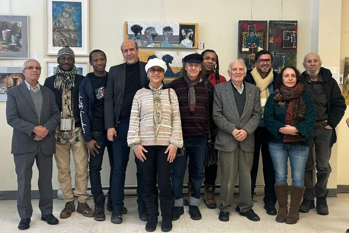 Le commissaire de l’exposition, le président d’honneur du Rallye-Expos 2026 et le fondateur du Festival Vues d’Afrique entourés de plusieurs artistes exposants, lors du vernissage au Centre NA-RIVÉ, à Montréal, le 7 février. © Astrid David de Vignerte