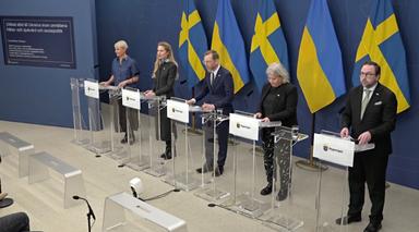 Ministres suédois debout derrière des pupitres lors d'une conférence devant les drapeaux suédois et ukrainiens