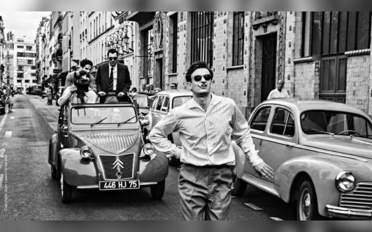 Un homme marche devant une voiture. Extrait du film. 