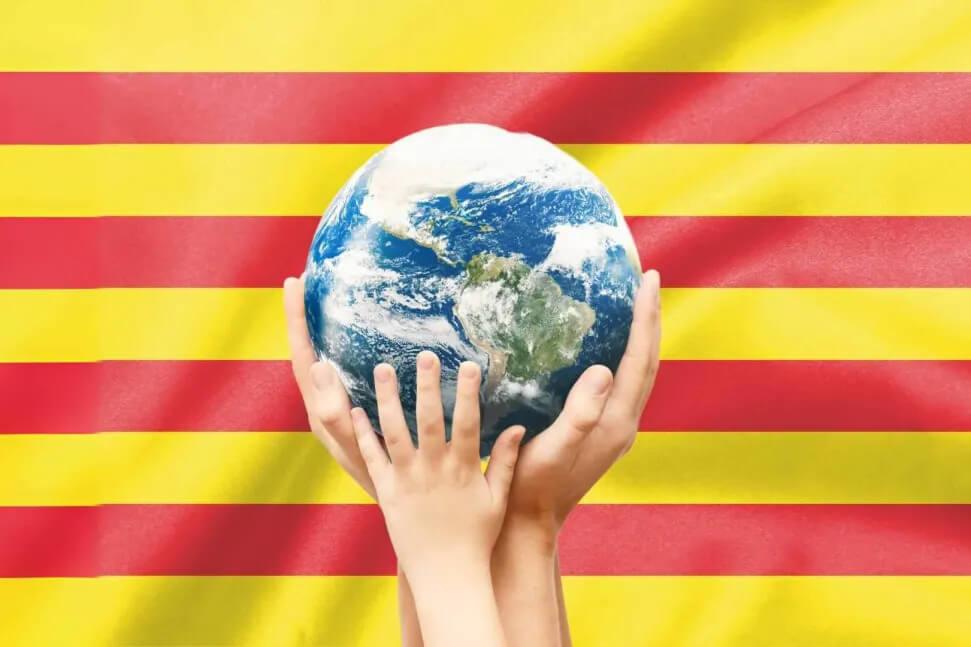 dreapeu catalan avec des mains tenant la terre au premier plan