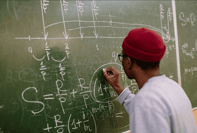 Etudiant écrit sur un tableau 