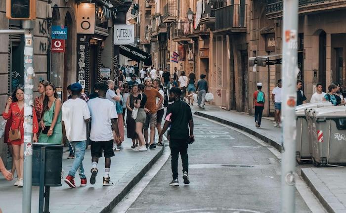 des passants de dos issus de la diversité dans une rue de barcelone
