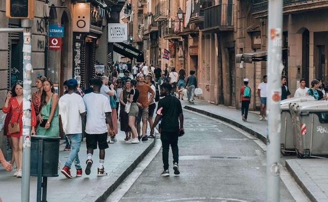 des passants de dos issus de la diversité dans une rue de barcelone
