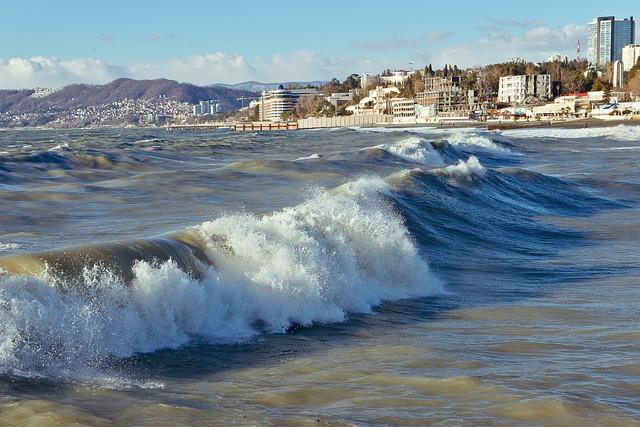 Une ville côtière vue depuis une plage, la photo étant faite à hauteur des vagues