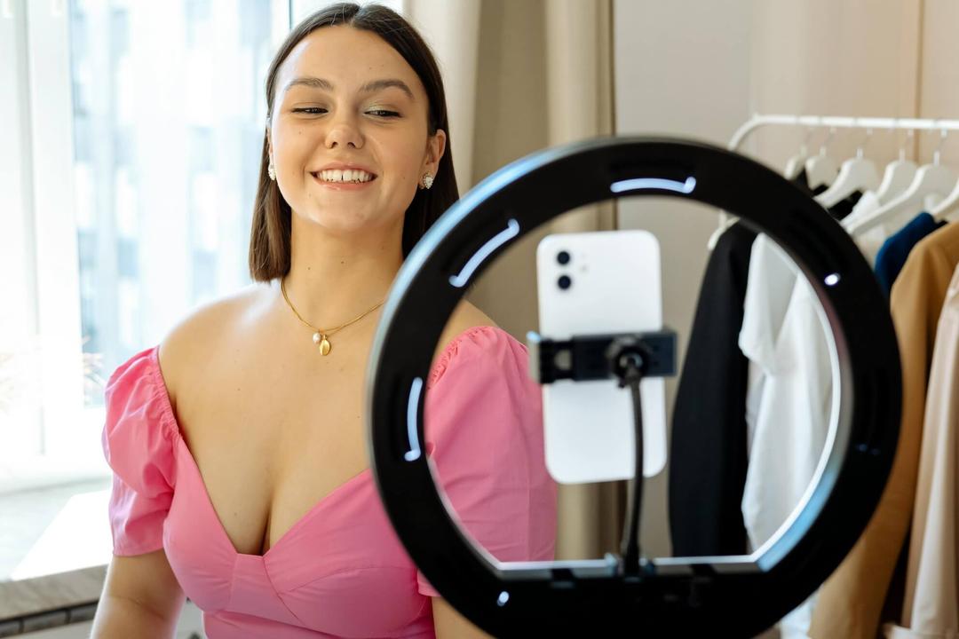 Une jeune influenceuse expatriée en Espagne en train de se filmer avec une ring light