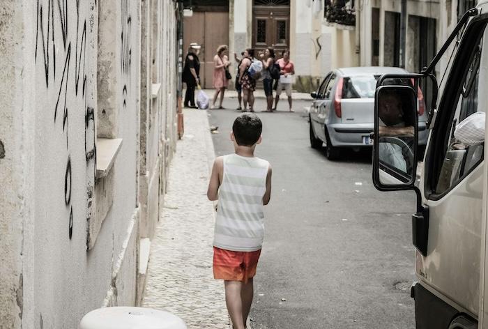un enfant pauvre marchant de dos dans une ruelle en espagne