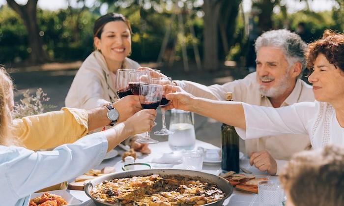 Des retraités partagent un repas convivial autour d’une paella en plein air en Espagne