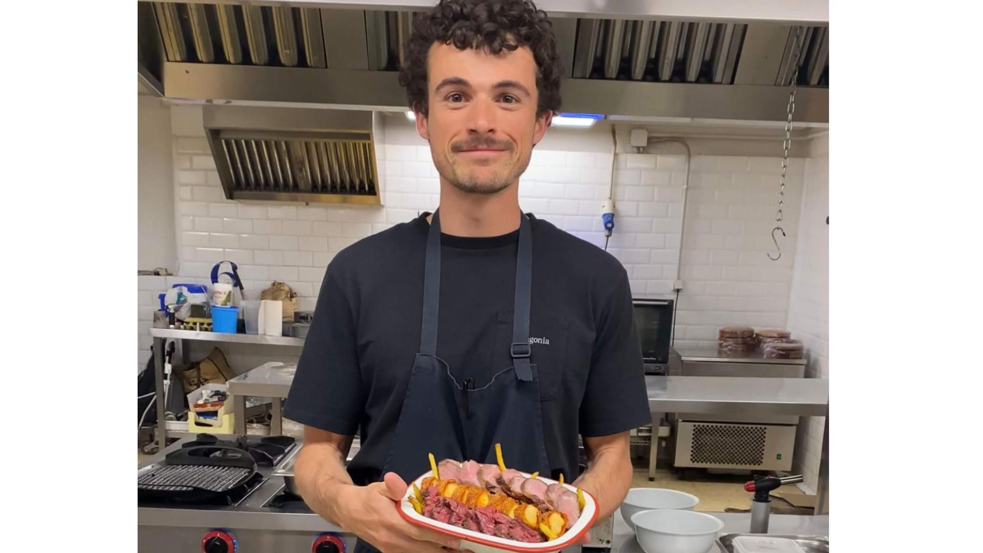Un homme tient un plat dans ses mains dans une cuisine