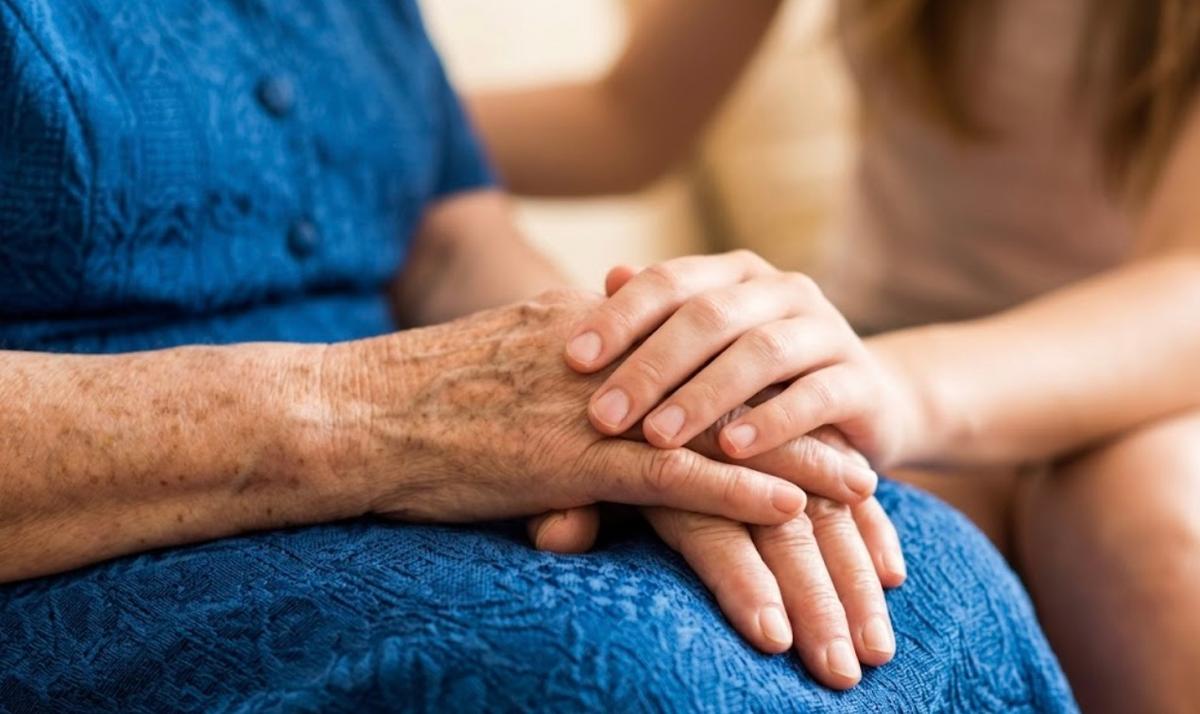 La main d'une personne agée tenant la main d'une personne plus jeune