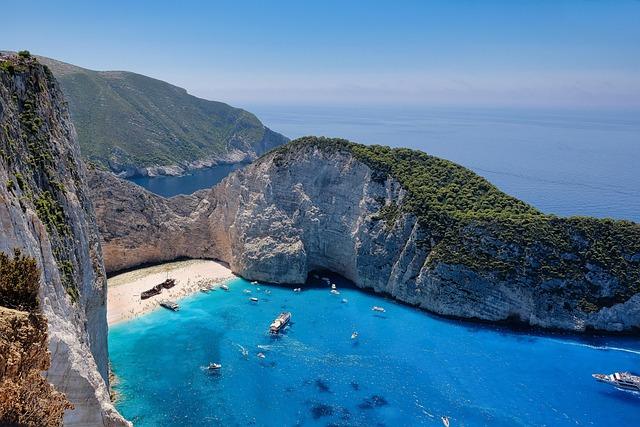 Vue de face d'une crique avec une plage se trouvant au fond, une épave étant échouée sur le sable 