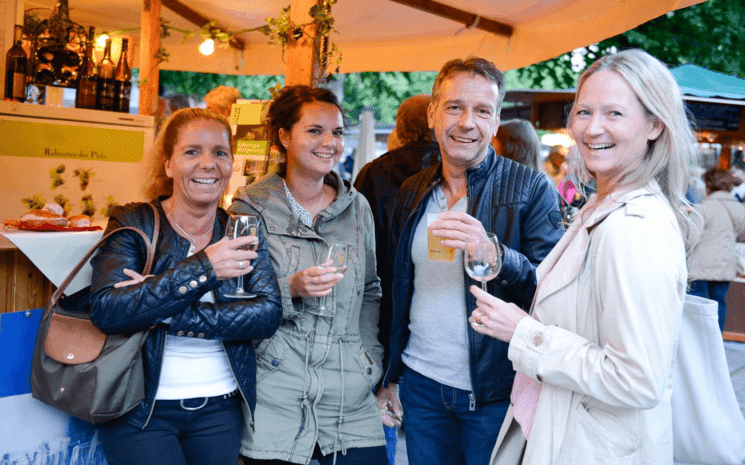 Quatre personnes boivent du vin tout en gaieté.