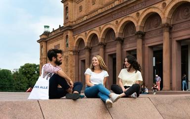 Trois personnes assises devant la Hamburger Kunsthalle.
